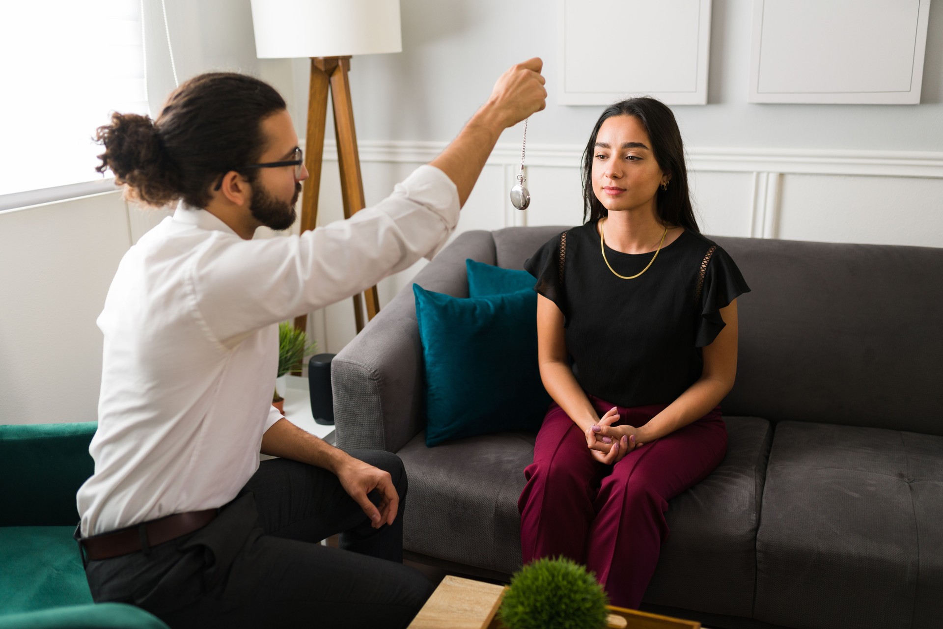 Latin psychologist hypnotizing a young woman